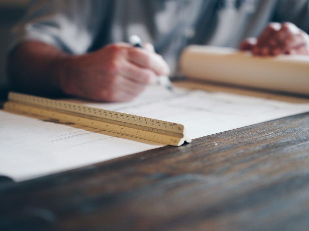 Architectural plans being reviewed by hand