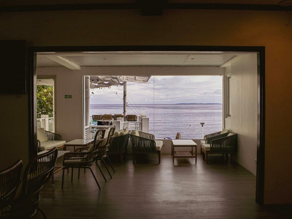 A calm living room with large windows facing the sea